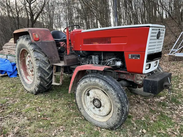 Piros traktor az erdő szélén
